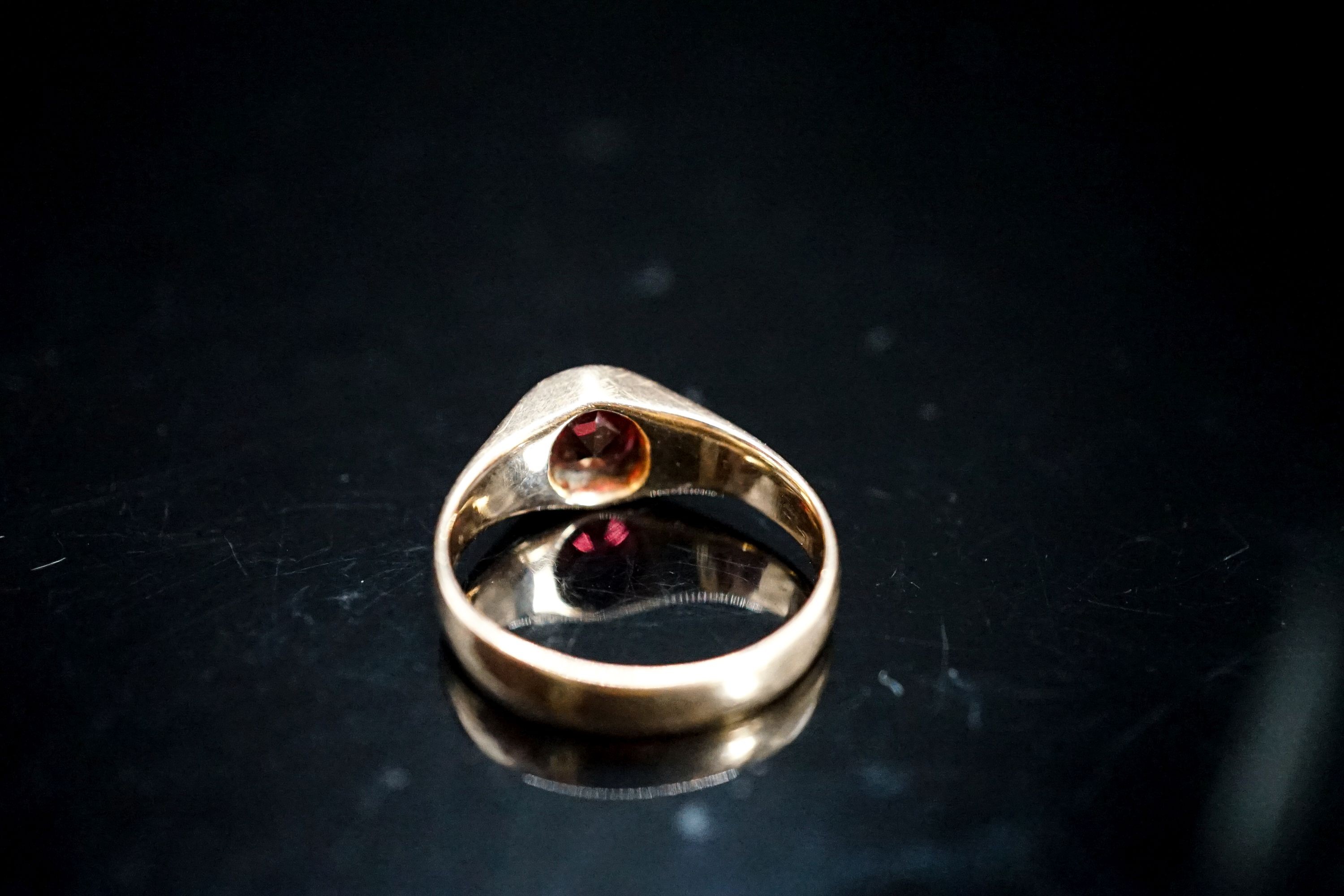 A yellow metal and garnet set ring, size N, gross 4.5 grams.